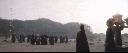 People Standing In Field With Chinese Writing GIF