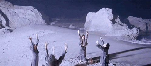 People Standing On Snowy Field With Arms Up GIF