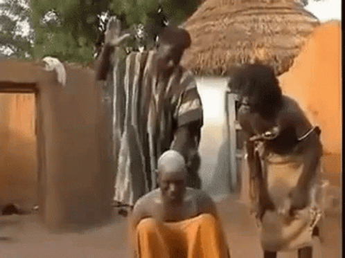 People Surrounding Man On Ground In Village GIF