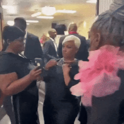People Talking in Hallway Woman with Pink Flower