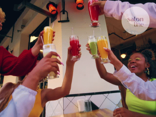 People Toasting Drinks In Front Of Salon Sign GIF