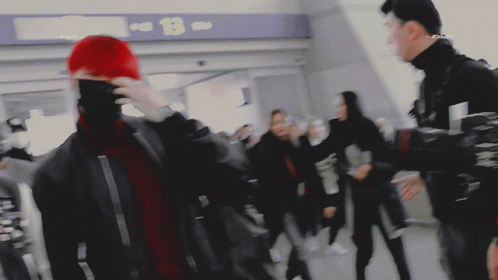 People Walking in Front of B Sign