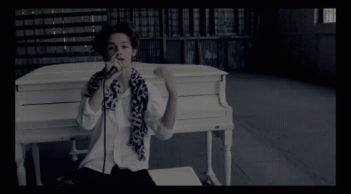 Person at White Piano With Scarf Saying SKS