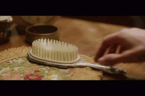 Person Brushing Hair With Silver Brush