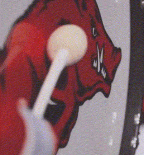 Person Brushing Teeth in Front of Drawing of a Boar