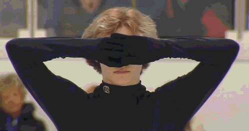 Person Covering Eyes in Black Shirt With Letter G