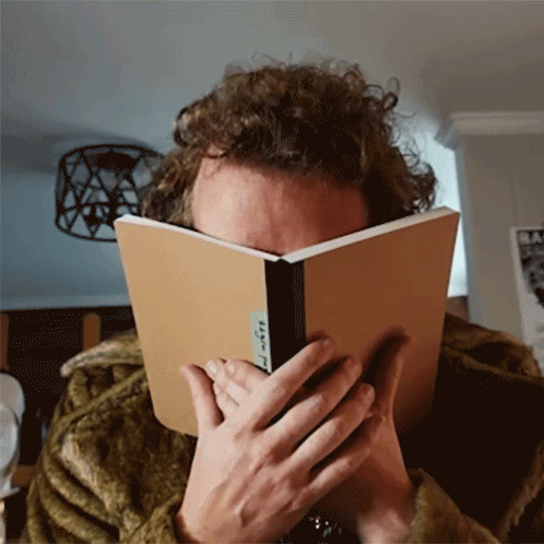 Person Covering Face With Book Saying A