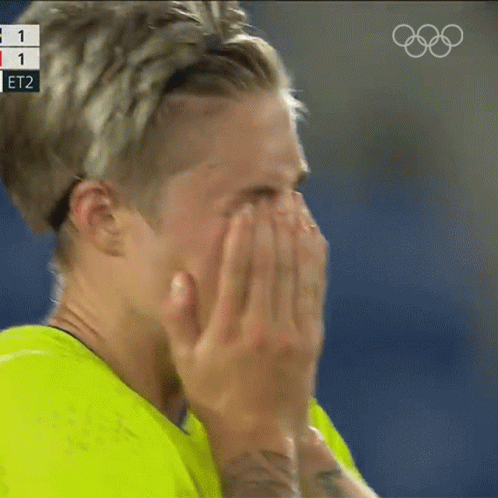 Person Covering Face With Hands Olympics Logo Behind GIF