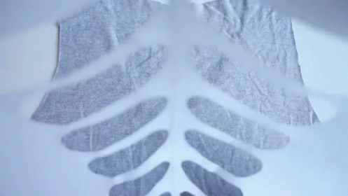 Person Cuts Skeleton From Fabric GIF
