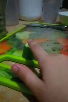 Person Cutting Cucumber With Green Knife GIF