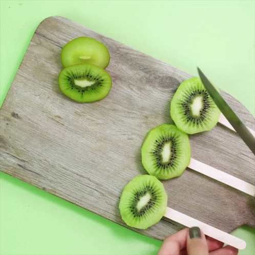 Person Cutting Kiwi Slices