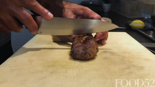 Person Cutting Meat on Cutting Board With Food52
