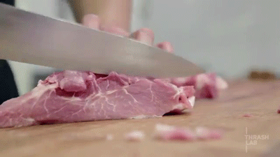 Person Cutting Meat With Thrash Lab