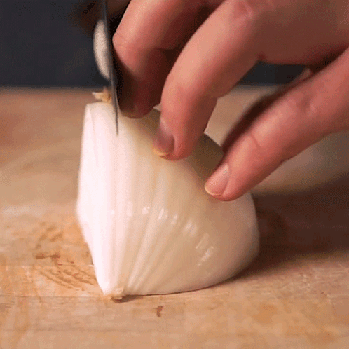 Person Cutting Onion With Knife
