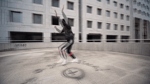 Person Dancing in Front of Building with Black Text