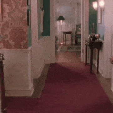 Person Dancing on Red Carpet in Hallway
