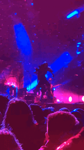 Person Dancing on Stage with Purple Lights