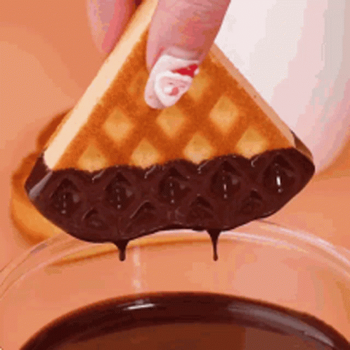Person Dipping Waffle Into Chocolate Sauce
