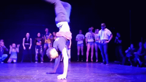 Person Doing Handstand in Front of Group Wearing Life Shirts