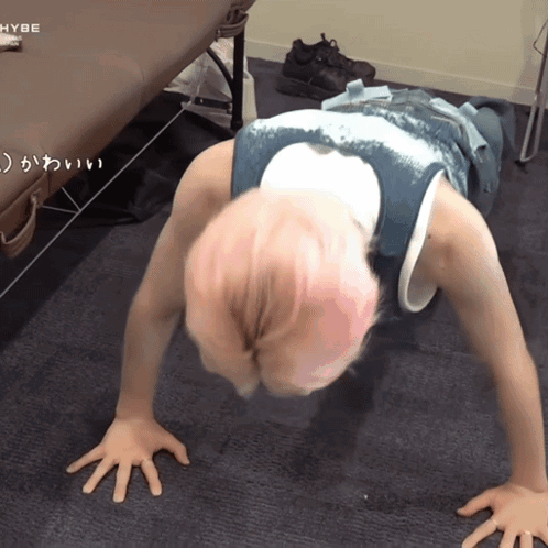 Person Doing Push Ups With HYBE Logo