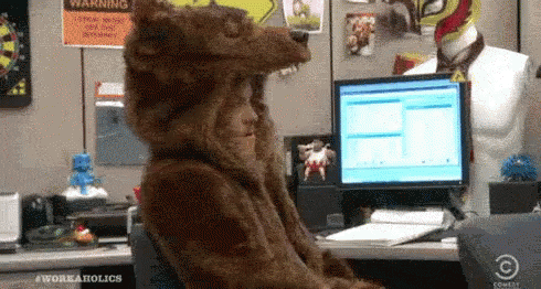 Person Dressed as Bear at Computer