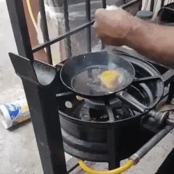 Person Frying Egg on Stove