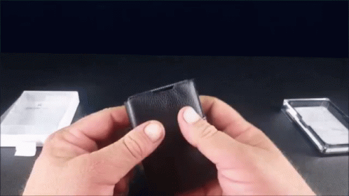 Person Holding Black Leather Wallet Next to Clear Plastic Case