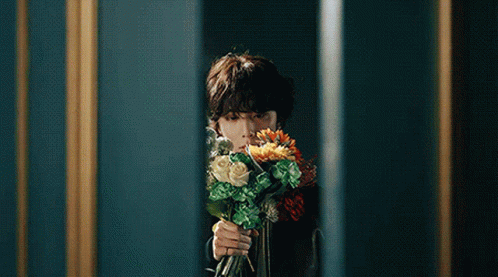 Person Holding Bouquet of Flowers in Front of Mirror