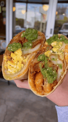 Person Holding Burrito With Eggs and Guacamole