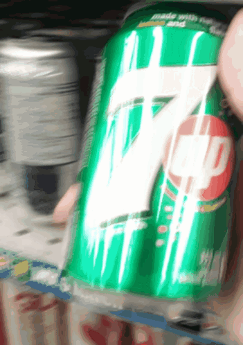 Person Holding Can of 7 Up