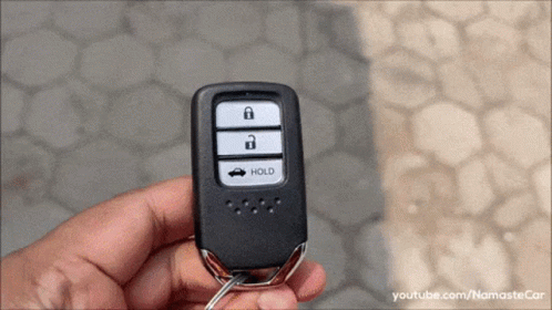 Person Holding Car Key With Hold Button