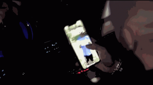 Person Holding Cell Phone With Man on Screen