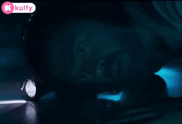 Person Holding Flashlight in Dark Room