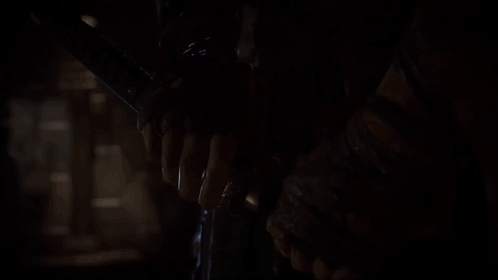 Person Holding Flashlight in Dark Room