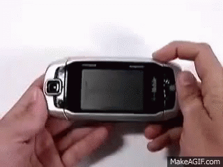 Person Holding Flip Phone Looking at It