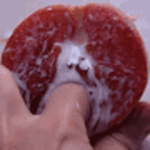 Person Holding Grapefruit Slice with Juice