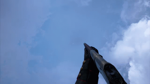 Person Holding Gun in Front of Blue Sky