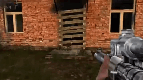 Person Holding Gun in Front of Brick Building