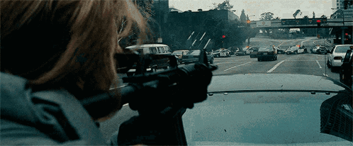 Person Holding Gun in Front of Van