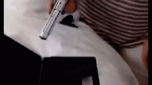 Person Holding Gun on Tablet