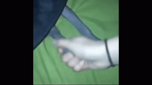 Person Holding Hand on Green Blanket