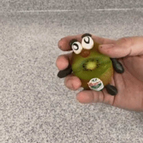 Person Holding Kiwi with Googly Eyes and Legs