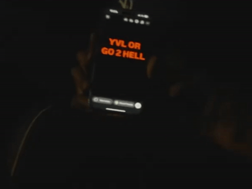 Person Holding Phone Saying yvl or go2 hell
