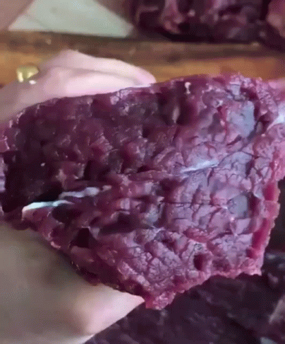 Person Holding Piece Of Purple Meat GIF