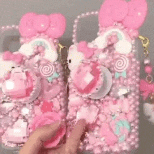 Person Holding Pink Hello Kitty Phone Case and Purse