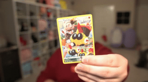 Person Holding Pokemon Card With Yellow Pokemon