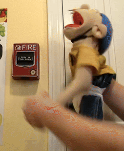 Person Holding Puppet At Fire Alarm GIF