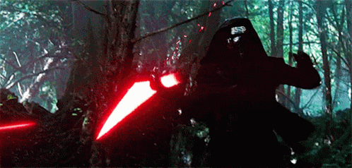 Person Holding Red Light Saber In Forest GIF