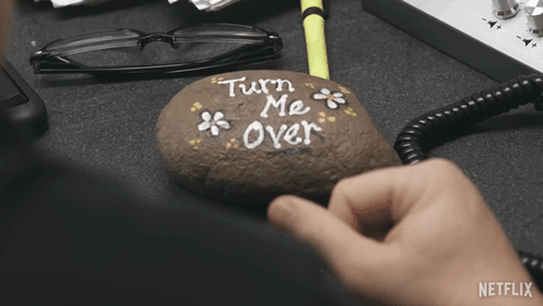 Person Holding Rock Saying Turn Me Over