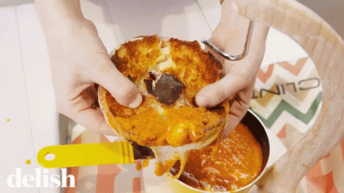Person Holding Sandwich Near Delish Sauce GIF